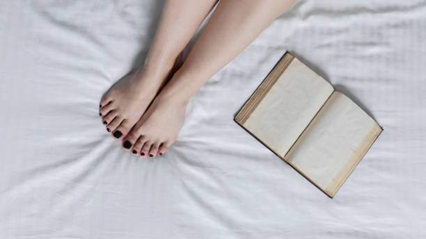 istock Book by the woman legs 671756794