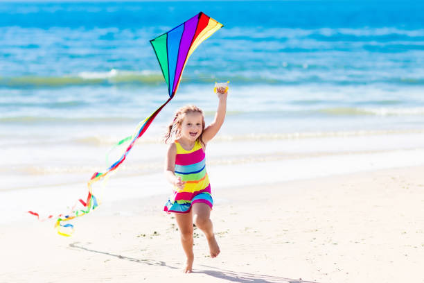 istock Child flying kite on tropical beach 671757548