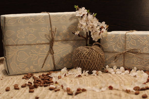 geschenk in der box und ein ast eines blühenden baumes - coffee bean coffee flower ribbon stock-fotos und bilder