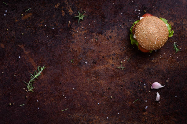 Grilled beef burger with lettuce and mayonnaise on a rustic table or counter.