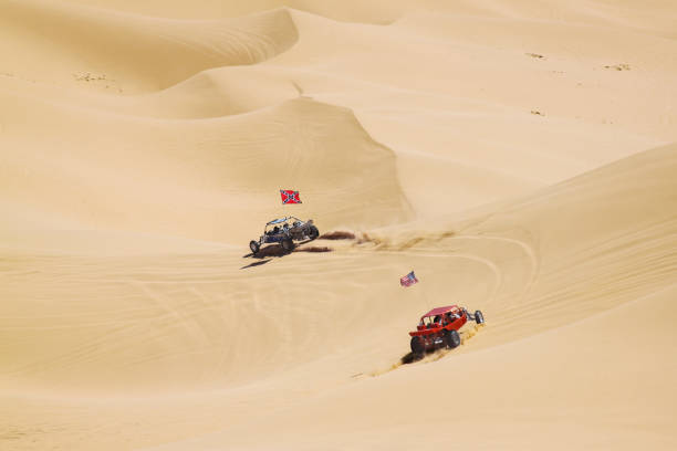 Couple of ATV riders kicking off sand in vast california desert