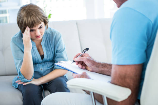 istock Woman looking at doctor writing on clipboard 671776190