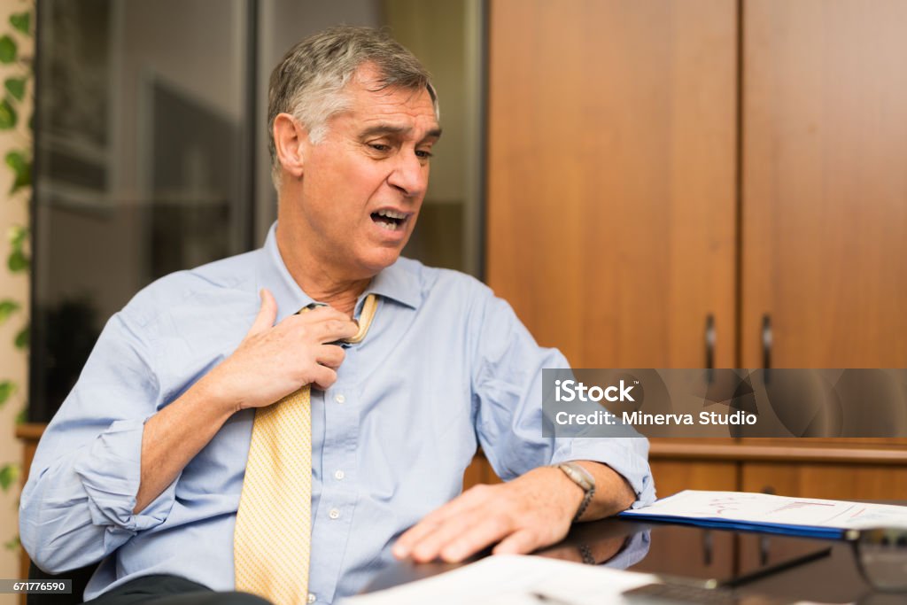 Businessman sweating in his office Business man sweating in his office Heat - Temperature Stock Photo