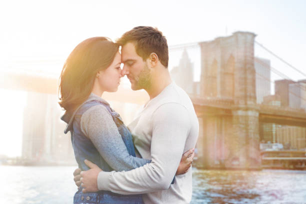 istock Two young lovers embracing at sunset in front of Brooklyn bridge 671783864