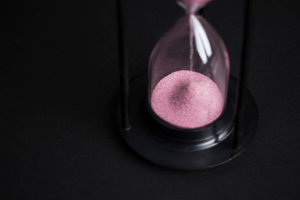 istock Large black hourglass against a black background 671787038