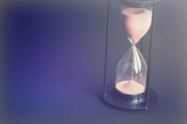 istock Large black hourglass against a black background 671787076
