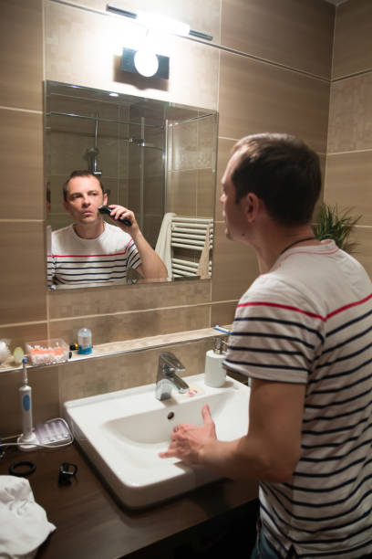 istock Handsome man shaving in the mirror in the bathroom 671789718