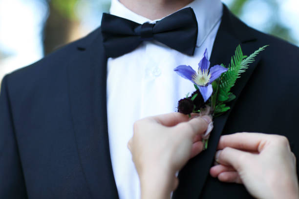 istock Bride adjusting boutonniere on grooms jacket 671789798