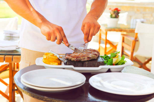 istock Man cooking beaf steak on hot stone 671790220