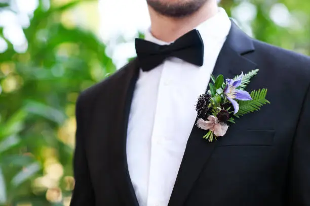 Gentle groom boutonniere with roses, chrysanthemum and beads