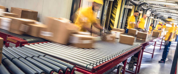 istock Postal workers inspecting packages on a conveyor belt 671803192