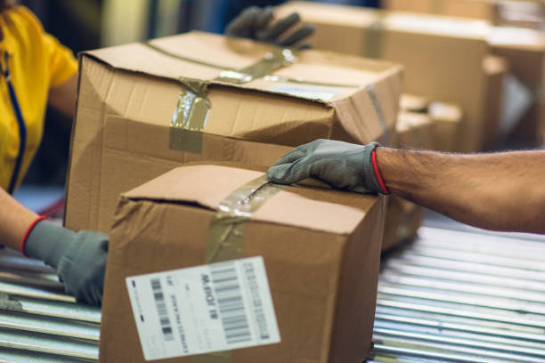 istock Close up of postal workers handling damaged packages 671803326
