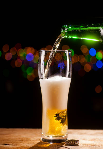 istock Beer is pouring into glass on bar lights background 671803620