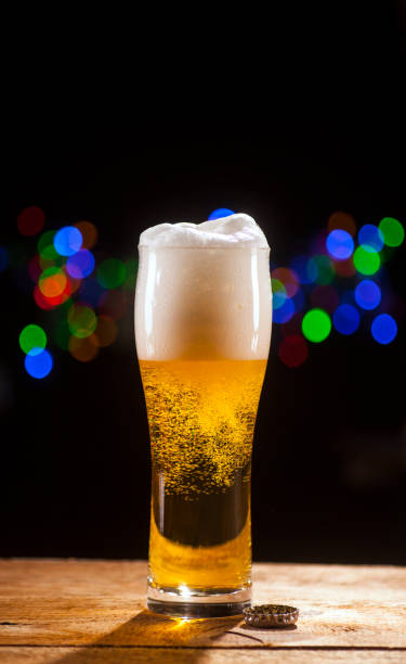 Glass of beer on bar lights background