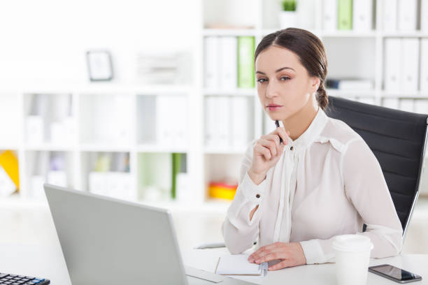 istock Businesswoman working on laptop with pen, side 671809198