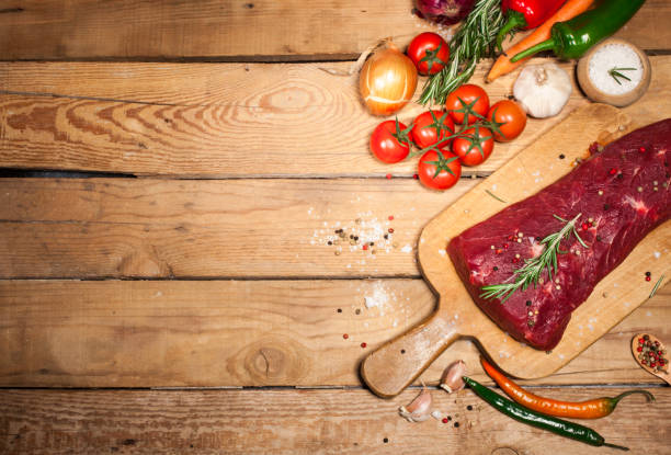 istock Raw beef steak on a cutting board with rosemary and spices. 671816176