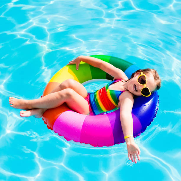 istock Child with toy ring in swimming pool 671823156