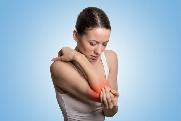 Joint inflammation indicated with red spot on female's elbow. Arm pain and injury concept. Joint inflammation indicated with red spot on female's elbow. Arm pain and injury concept. Closeup portrait woman with painful elbow on blue background joint body part photos stock pictures, royalty-free photos & images