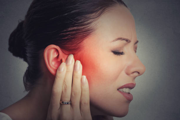 Closeup up side profile sick female having ear pain touching her painful head stock photo