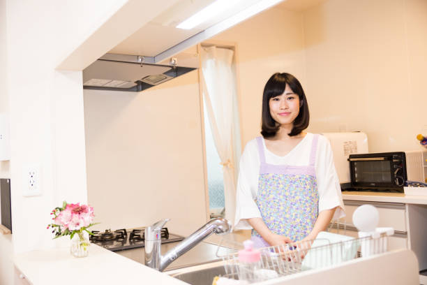 istock Japanese woman standing in bright kitchen 671825880