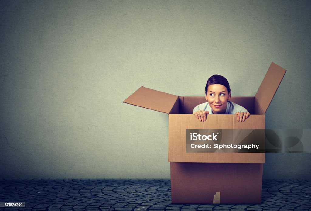 Young woman coming out from a box Leaving Stock Photo