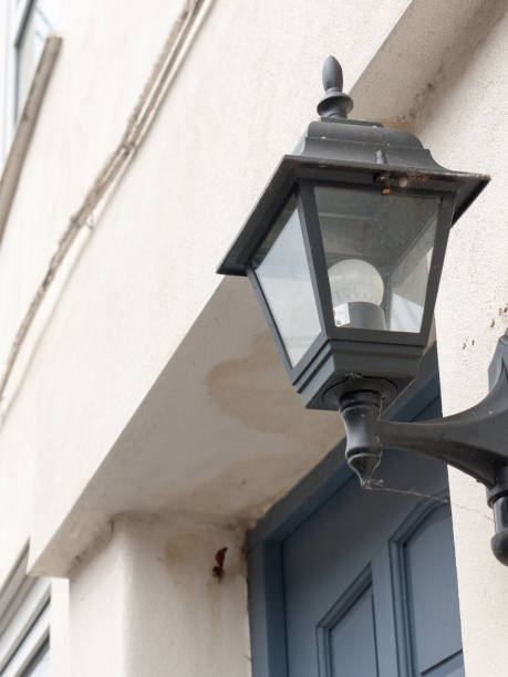 istock a black lantern outside with the light turned off during the day serious and austere old fashioned victorian with white walls and blue door behind 671832528
