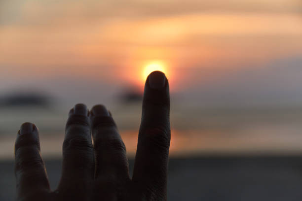istock Human's finger pointing to the sun 671836208