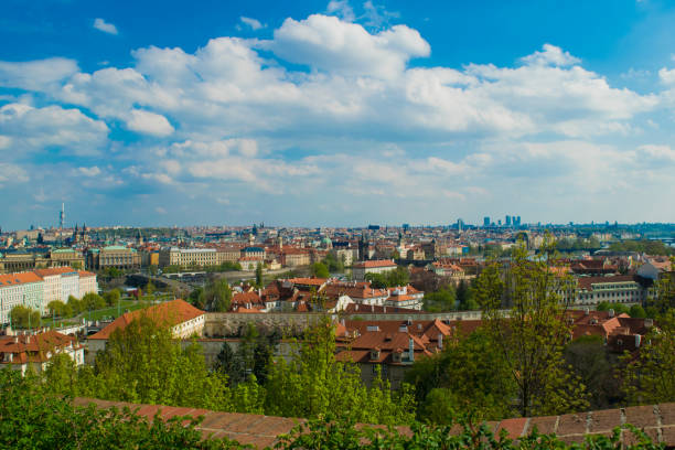 The captivating skyline of Prague reveals a mix of historic buildings and colorful rooftops bathed in warm hues at sunset creating a picturesque urban panorama.