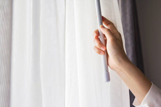 istock Young woman opening curtains in bedroom 671874146
