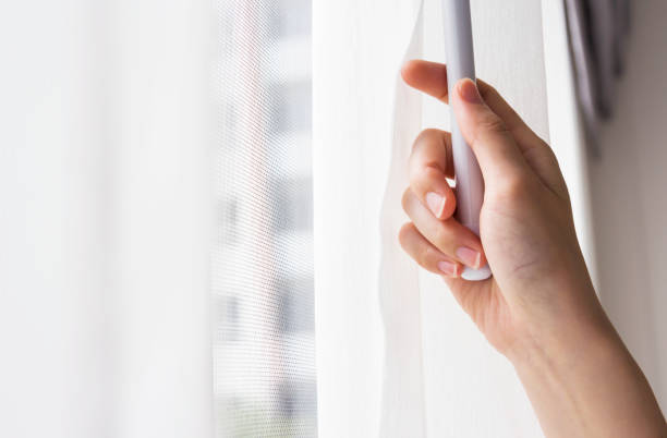 istock Young woman opening curtains in bedroom 671874222
