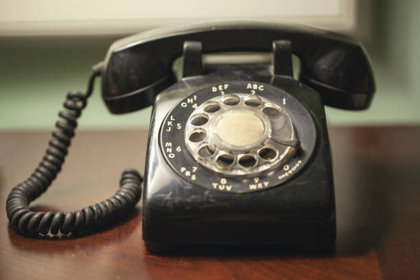 teléfono rotatorio negro vintage retro antiguo en un escritorio - enzo fotografías e imágenes de stock