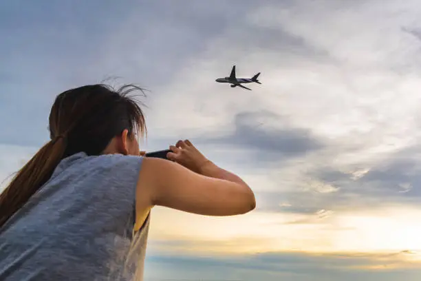Photo of Girl taking airplane photo