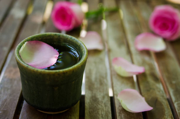 petali di rosa rosa con una tazza da tè su tavolo di legno - murraya paniculata foto e immagini stock