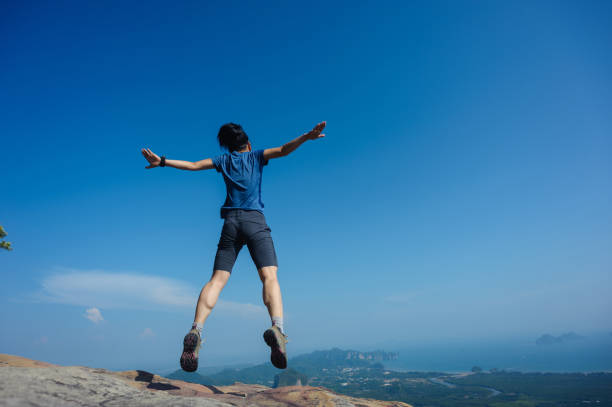 istock jumping on rocky mountain peak, freedom, risk, challenge, success concept 671889820