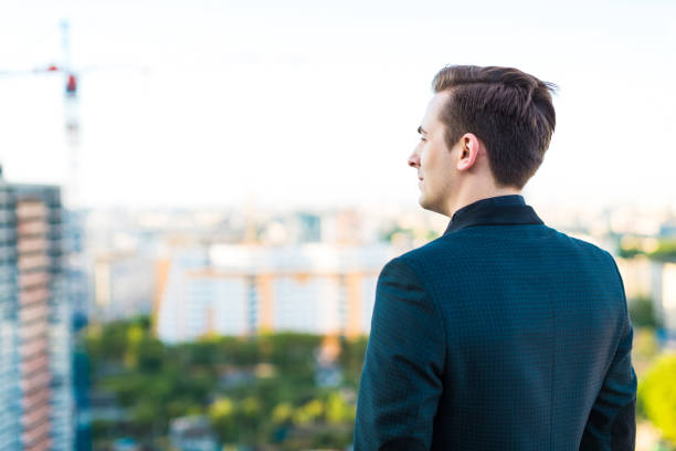 istock Attractive serious busunessman in dark suit and black shirt 671925338