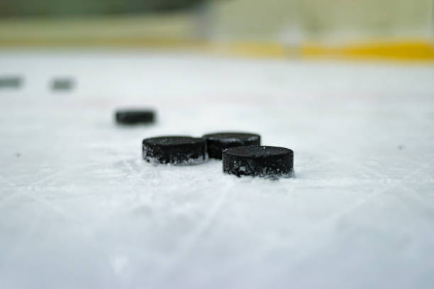 istock Hockey puck on ice 671945584