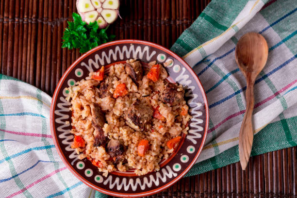 istock Pilaf on the brown plate on a wooden table, background. Rustic style.  Top view. 671958846