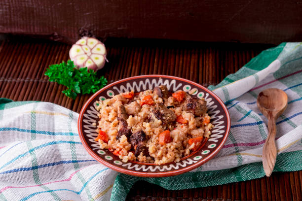 istock Pilaf on the brown plate on a wooden table, background. Rustic style. 671958850