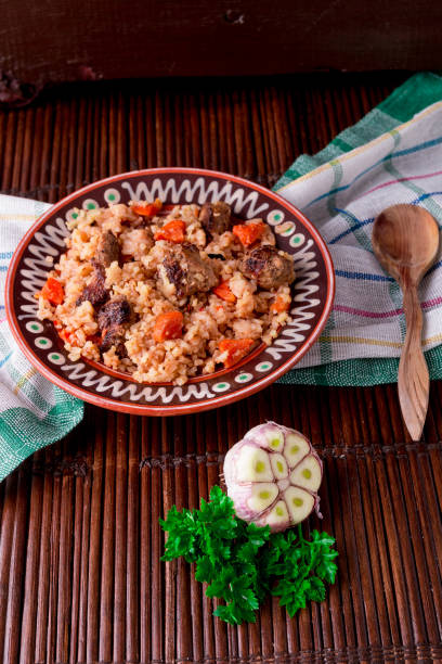 istock Pilaf on the brown plate on a wooden table, background. Rustic style. 671958856