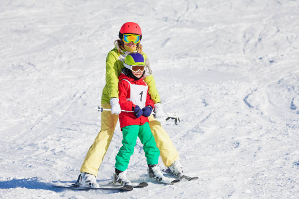 istock Female trainer teaching boy skiing at sunny day 671958998