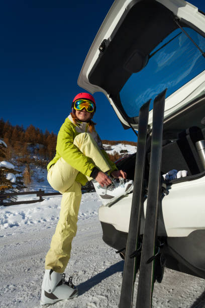 istock Smiling female skier putting her ski boots on 671961578