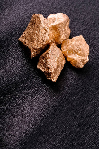 istock Gold nuggets on a black background leather. Closeup. 671965150