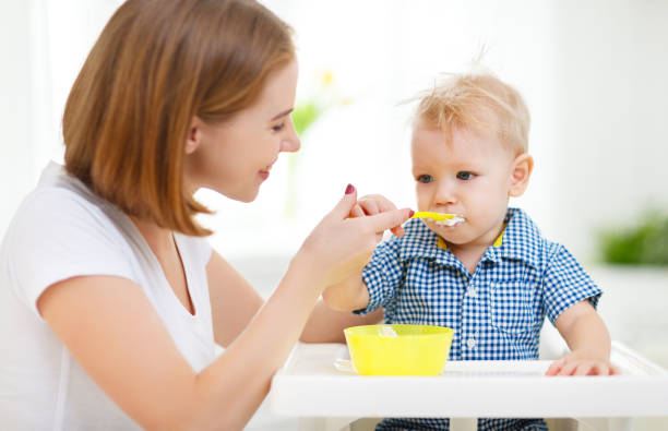 istock Mother feeds baby from spoon 671968656