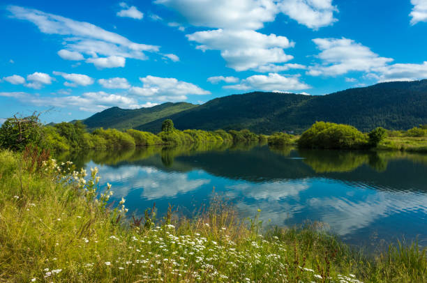 Kosinj Croatia Europe. Beautiful nature and landscape photo. Colorful warm summer day. Nice outdoors image. Green grass, blue sky and lovely river. Calm, peaceful, joyful and happy picture.