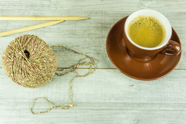 istock Wool ball with a cup of coffee and needles 671972492
