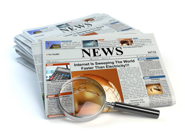 istock News concept. Newspapers and magnifying glass isolated on white. 672001500