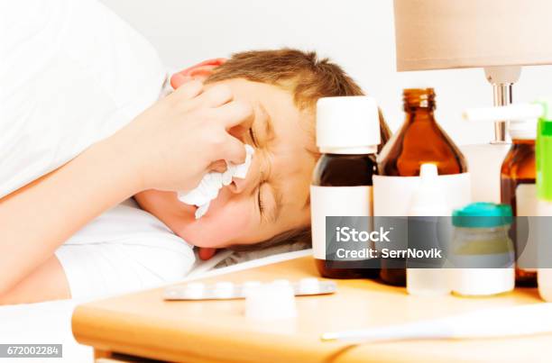 Sick Kid Boy With Bad Cold Using Paper Napkins Stock Photo - Download Image Now - 6-7 Years, Bed - Furniture, Bedroom