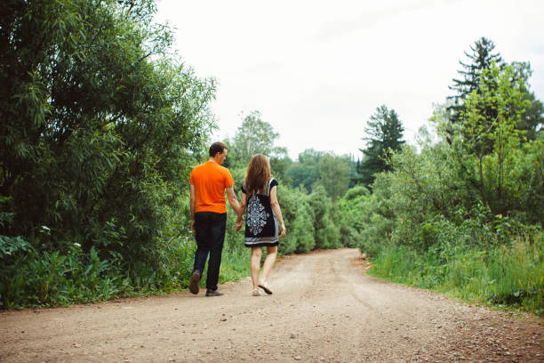 istock the guy with the girl walking on a forest road 672008204
