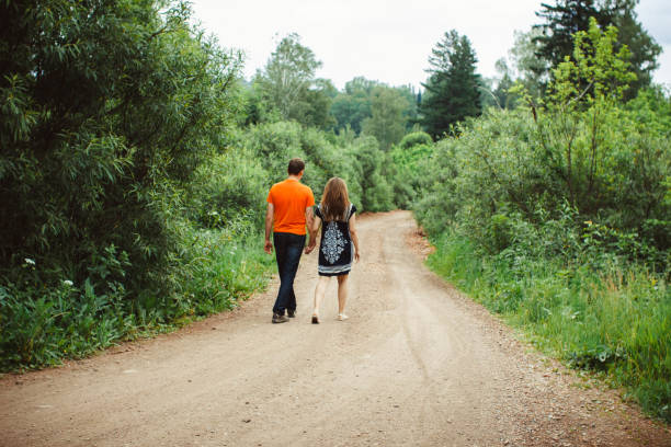 istock the guy with the girl walking on a forest road 672008248