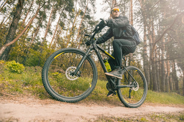 istock Man Rides a Bike in the Forest 672010878